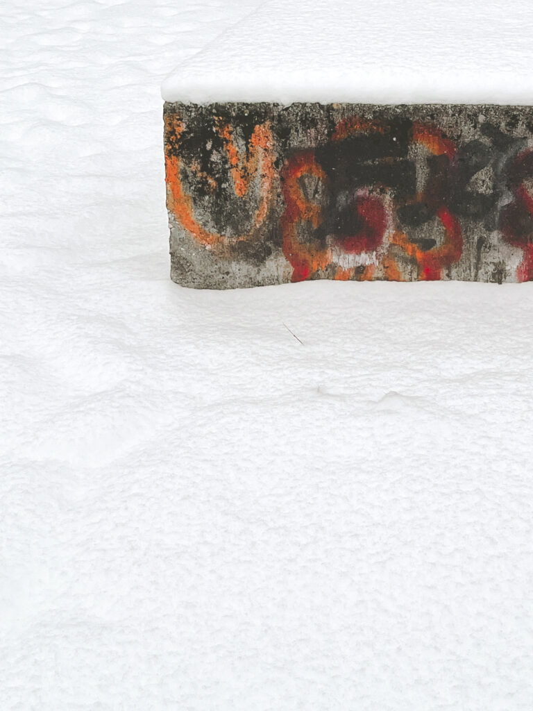 Photo of a graffitied concrete slab in the snow